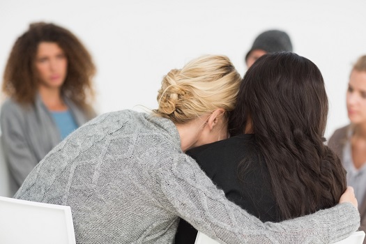 Women embracing at a meeting